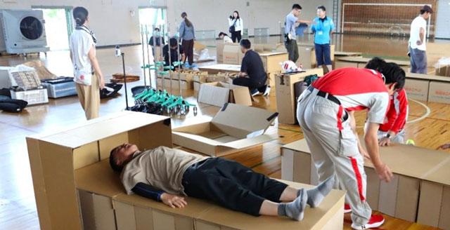 P5 2 「酷暑期避難所演習」より段ボールベッド設置 - 弘前大の<br>産学連携「酷暑期避難所演習」